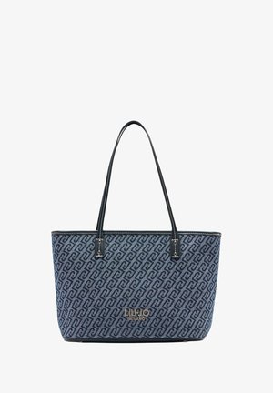 Tote bag van marineblauw stof met een patroonontwerp. Zwarte leren handvatten en accenten, met een gouden logo aan de voorkant.