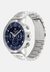 Montre en acier inoxydable avec un cadran bleu marine, des accents argentés, des fonctions chronographe et un bracelet métallique à maillons. Design résistant à l'eau.