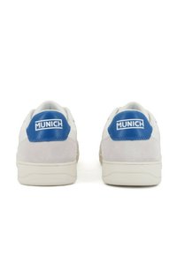 Baskets en suède blanc avec un contrefort en synthétique bleu portant le logo "MUNICH", semelle en caoutchouc plate et un design épuré.