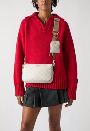 Beige checked crossbody bag with gold accents, featuring a small detachable pouch. Worn over a red knit sweater and a black plaid skirt.