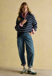 Merevöödid, roosa kraega särk all, sinised teksad, rohelised ja valged tossud, üleskeeratud varrukad ja mugav lõige.