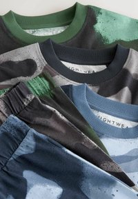 Vêtements en coton de différentes couleurs : vert foncé, marine, gris et bleu, avec des motifs abstraits et des cols côtelés texturés.