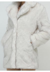 Cappotto in pelliccia sintetica di colore crema chiaro con una texture soffice, collo a revers e tasche laterali. Design di lunghezza media con un aspetto morbido e lussuoso.