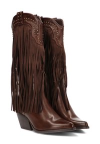 Botas de vaquero de cuero marrón con flecos largos, punta afilada, tacón apilado y remaches decorativos en la parte superior. Textura suave en toda su extensión.