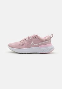 Baskets de sport roses avec une tige en mesh, semelle rembourrée et accents blancs. Présente des motifs texturés et un petit tabouret au talon pour un enfilage facile.