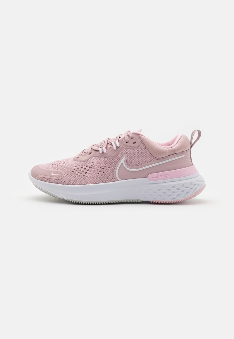 Baskets de sport roses avec une tige en mesh, semelle rembourrée et accents blancs. Présente des motifs texturés et un petit tabouret au talon pour un enfilage facile.