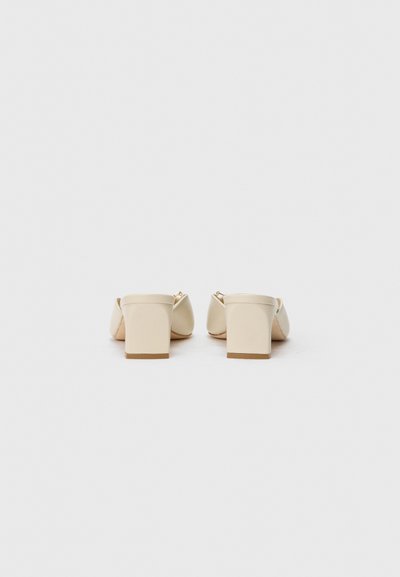 Mules à talents beige avec une finition lisse, dotés d'un bout arrondi et d'un design minimaliste. Construction légère.