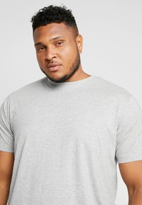 Gray short-sleeve t-shirt with a rounded neckline, made of soft fabric, featuring a smooth texture and minimalistic design.