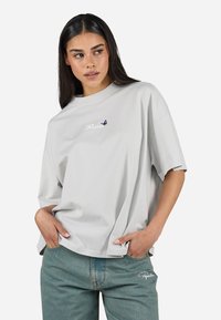 Kortermet grå bomull t-skjorte med løs passform, med brodert "Elegador" tekst og en liten lilla sommerfugl akcent.
