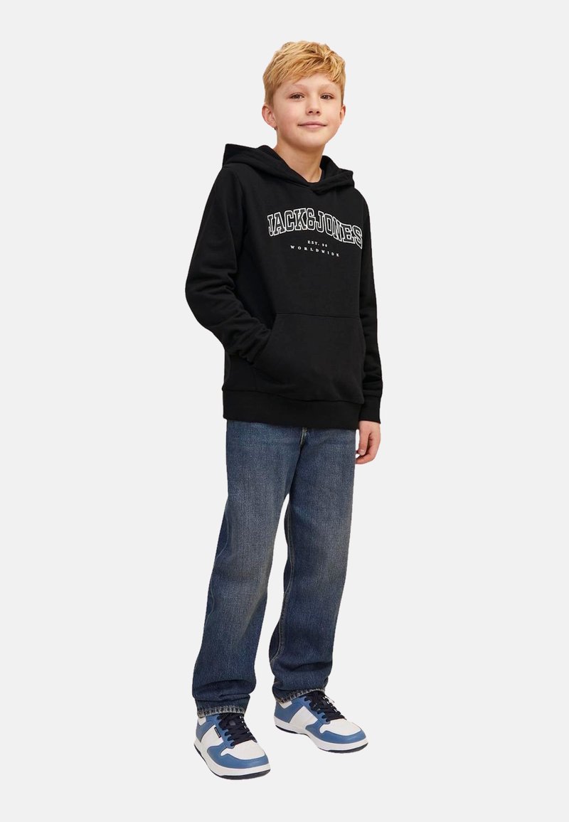 Black hooded sweatshirt with white logo text, front kangaroo pocket, paired with blue denim jeans and blue/white sneakers.