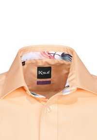 Camicia a maniche corte color pesca con superficie texturizzata, dotata di un colletto interno a motivo floreale e di un'etichetta nera con il logo "Kauf". Vestibilità regolare.