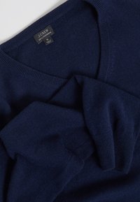 Maglione in cashmere blu navy con design a V. Texture morbida, polsini e orlo a coste, con etichetta J.Crew nell'area del collo.