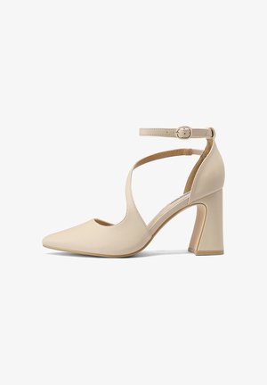 Scarpa con tacco alto beige a punta, con cinturino alla caviglia e fibbia, caratterizzata da un design traforato sul lato e tacco a blocco.