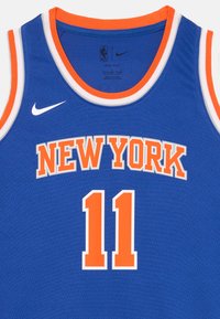 Plavi košarkaški dres s narančastim dijelovima. "NEW YORK" i broj "11" tiskan u narančastoj boji na prednjoj strani. Nike logo u crnoj boji na izrezu za vrat.