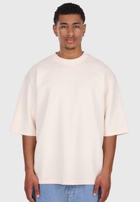 Lyserød oversized t-shirt lavet af blødt stof med korte, brede ærmer og rund halsudskæring. Subtil branding på ærmet.