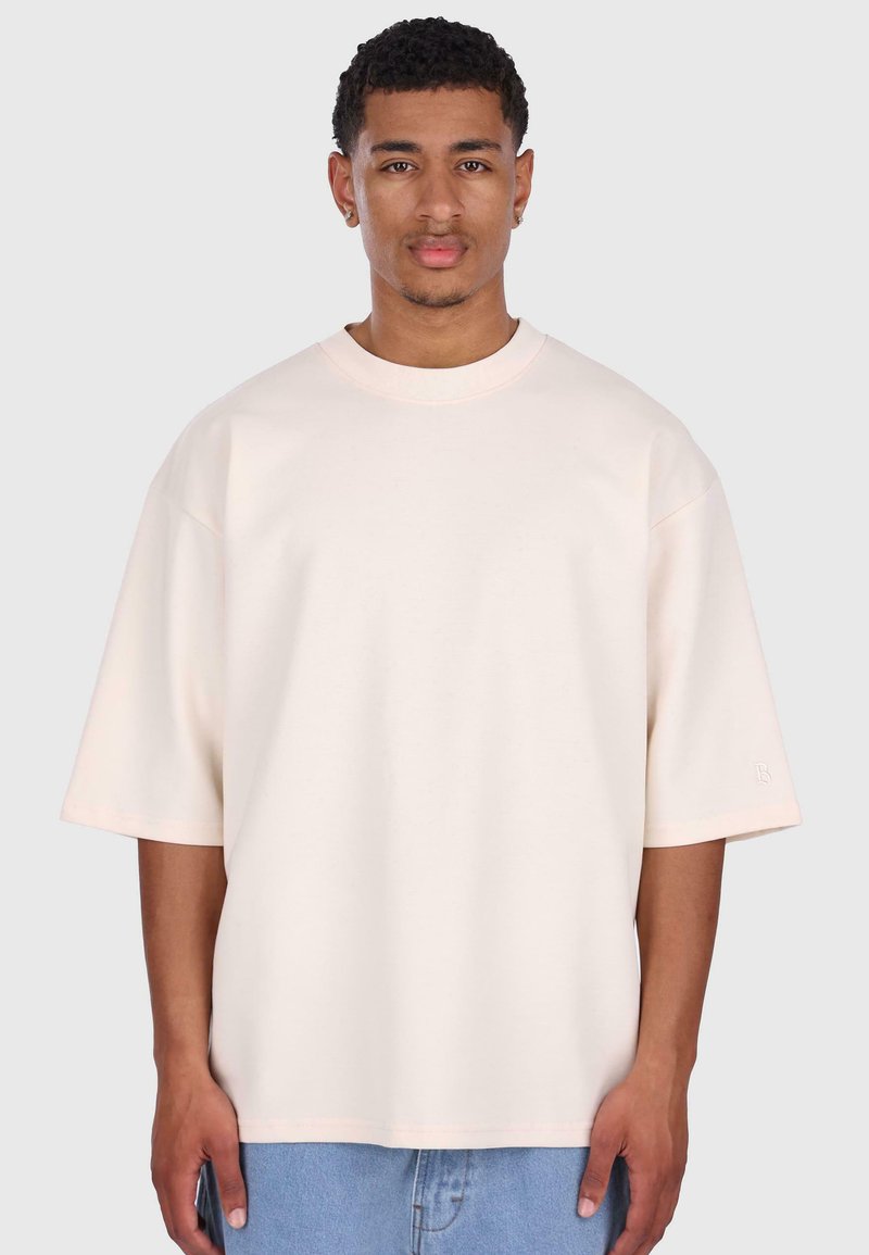 Lyserød oversized t-shirt lavet af blødt stof med korte, brede ærmer og rund halsudskæring. Subtil branding på ærmet.
