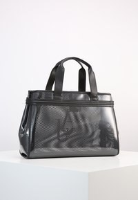 Černá perforovaná taška přes rameno s lesklým povrchem, dvojitými horními rukojetmi, obdélníkovým tvarem, zipovým uzávěrem a texturovaným vzorem povrchu.