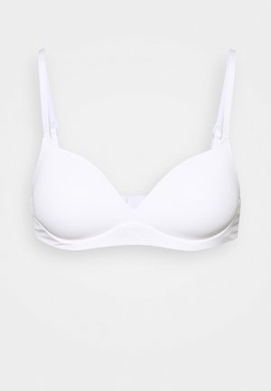 Soutien-gorge blanc avec des bonnets lisses et moulés, et des bretelles fines ajustables. Il présente un design sans coutures, une texture douce et un détail de marque subtil au centre.