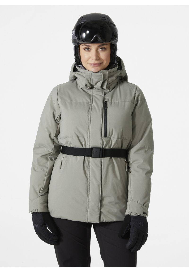 Lichtgrijze sneeuwjack met een capuchon, ritssluiting aan de voorkant, verstelbare zwarte riem, rits borstzak en zwarte handschoenen.