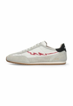 Niskoprofilowy sneaker z białego i jasnoszarego zamszu, czerwonym wzorem w zygzak po boku, gumową podeszwą i czarną zakładką na pięcie z białym napisem.
