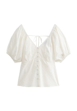 Witte blouse met opgestikte mouwen, V-hals en strik aan de achterkant. Beschikt over een knoopsluiting aan de voorkant en een uitgesneden bloemenpatroon in de stof.
