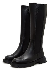 Botas negras hasta la rodilla, hechas de cuero suave y material elástico, con puntera redondeada y suela de goma gruesa con tracción.
