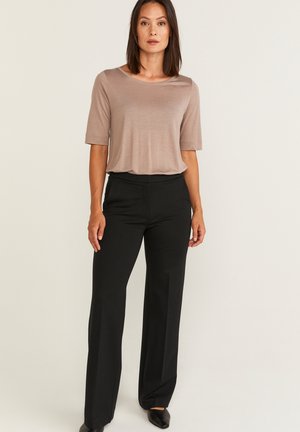 Beige short-sleeve top paired with black, wide-leg pants. The top has a smooth texture, while the pants have a tailored design and soft fabric.