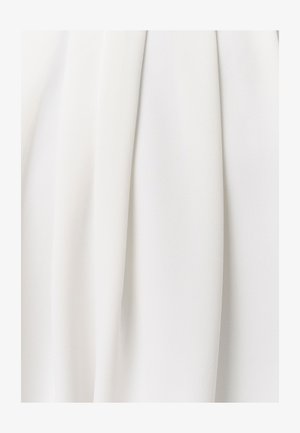 Balts audums ar mīkstām, plūstošām krokām un smalku teksturētu rakstu, kas rada maigas vertikālas ēnas un gaismas atspīdumus.