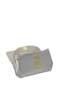 Petite pochette en cuir argenté avec boutons-pression dorés, partiellement ouverte montrant l'intérieur en daim doux.
