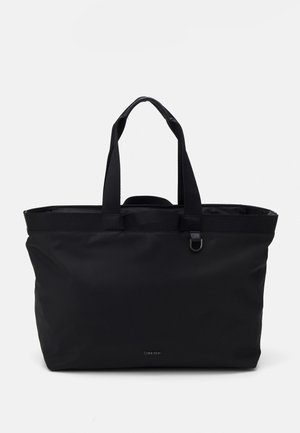 Sac fourre-tout noir avec des poignées en tissu doubles, une fermeture éclair et un design minimaliste. Présente un logo discret à l'avant. Matériau durable.