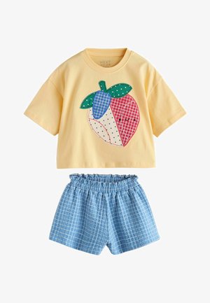 Geel crop top met korte mouwen en een multicolor patchwork fruitontwerp, gecombineerd met blauw-wit geruite shorts met een elastische tailleband.