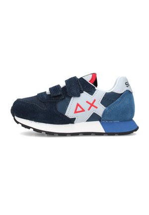 Scarpa da ginnastica blu navy e bianca con logo geometrico rosso, cinturini in velcro, tallone in suede blu e suola nera, vista laterale su sfondo bianco.
