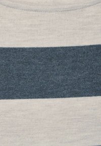 Randig tyg med en ljusbeige övre sektion, en mörkblå strukturerad mittstripe och en ljusbeige nedre sektion, ribbad struktur genom hela tyget.