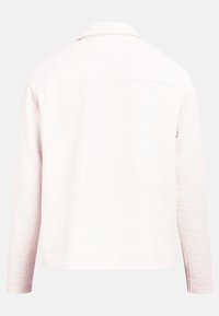 Ελαφρώς ροζ υφασμάτινο σακάκι με γεωμετρικά σχέδια, γιακά με κουμπιά, μακριά μανίκια και ευθεία κοπή, φαίνεται από πίσω.