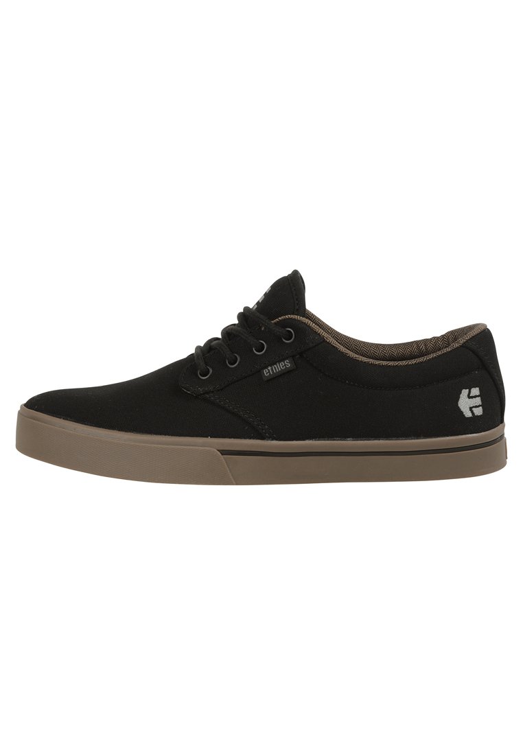 Black canvas sneakers with brown rubber sole, round toe, and lace-up closure. Features subtle branding on the side and patterned inner lining.