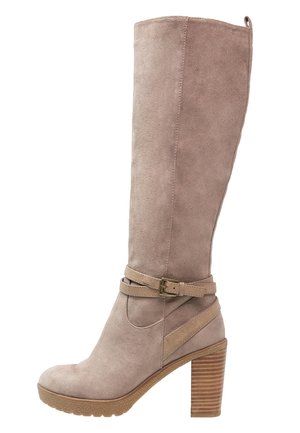Bota de ante topo hasta la rodilla con puntera redondeada, detalle de correa en el tobillo y tacón apilado con estrías horizontales.