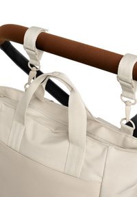 Beige szövet táska két füllel és levehető pánttal. Cipzáras zsebbel és texturált barna füllel rendelkezik.