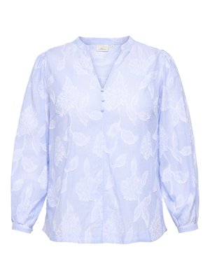 Bluza albastru deschis cu mâneci lungi, cu un model floral alb subtil, decolteu în V cu trei nasturi acoperiți cu material și mansete strânse.