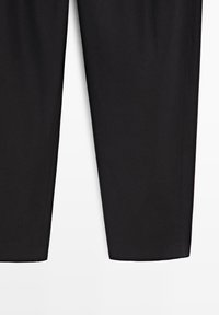 Pantaloni neri a gamba dritta con pieghe stirate sul davanti, mostrati dalla metà coscia all'orlo su sfondo bianco.