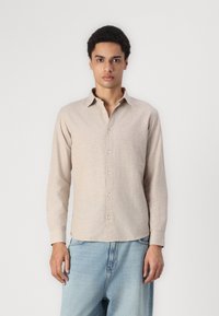 Light beige long-sleeve shirt with a button-down collar, made of a textured fabric, featuring a straight cut and front buttons.