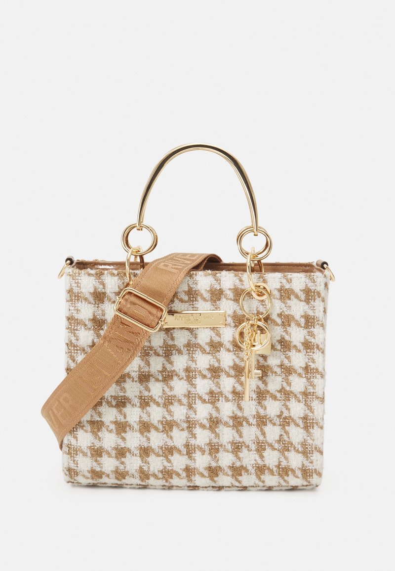 Petit sac à main en pied-de-poule marron et blanc avec ferrures dorées, bandoulière amovible, poignées courbées et un pendentif clé décoratif.