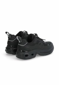 Zwarte chunky sneakers met dikke zolen met ronde uitsparingen, bovenwerk van mesh en synthetisch materiaal, veters en trekbanden met witte tekst.