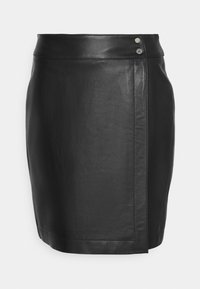 Mini-jupe noire en simili cuir avec un design portefeuille et double boutons-pression argentés à la taille.