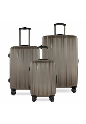 Tre valigie rigide di colore taupe metallico, con scanalature verticali, manici retrattili e quattro ruote nere per una facile mobilità.
