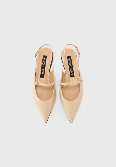 Pantofi slingback bej cu vârf ascuțit, cu o curea mică cu cataramă, din material de piele și cu o textură netedă; logo-ul este afișat proeminent pe interiorul tălpii.