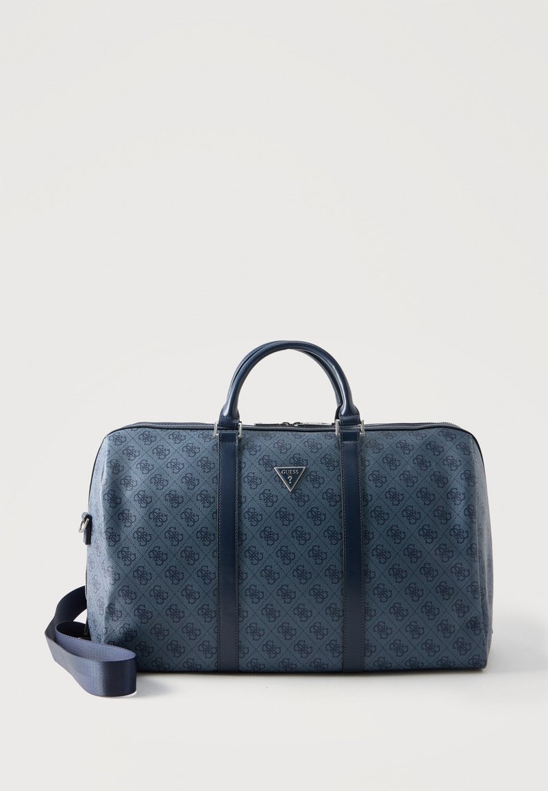 Σκούρα μπλε υφασμάτινη τσάντα duffel με πάνω λαβές, αποσπώμενο λουρί ώμου και τρίγωνο λογότυπο Guess στο εμπρός μέρος.