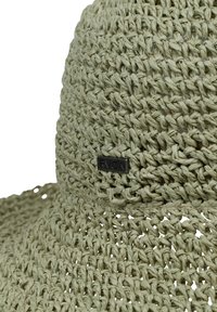 Green woven straw hat with a wide brim, featuring a textured surface and a black RVCA logo tag on the side.