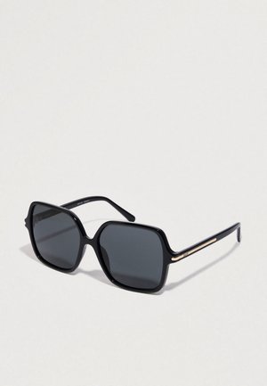 Black oversized sunglasses with square frames, gray lenses, glossy finish, and gold accent detailing on the temples.