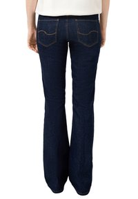 Dunkelblaue, ausgestellte Jeans mit glatter Textur. Die Gesäßtaschen zeigen dekorative Nähte. Der Stoff wirkt strapazierfähig und flexibel.