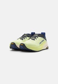 Scarpe da trail running di colore giallo chiaro con una superficie testurizzata, dettagli blu navy, suola nera e il marchio "Altra" sul lato. Logo Vibram presente.